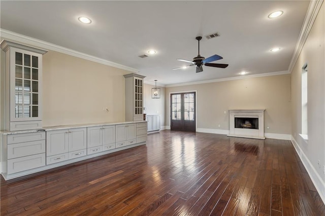 400 40th St, New Orleans, LA 70124 - unfurnished living room with dark wood-style flooring, a ceiling fan, baseboards, ornamental molding, and a fireplace with raised hearth