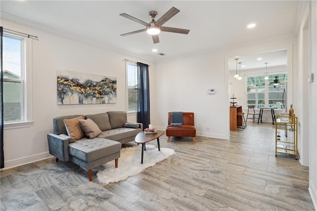 living area featuring ceiling fan, recessed lighting, baseboards, visible vents, and ornamental molding