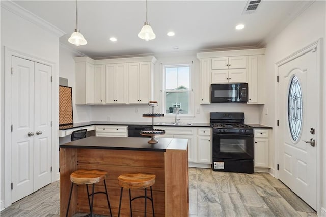 kitchen with visible vents, ornamental molding, dark countertops, a sink, and black appliances