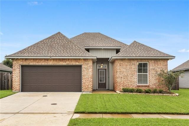 324 Ashton Oaks Ln, Luling, LA 70070 - view of front of property featuring brick siding, a shingled roof, a garage, and concrete driveway
