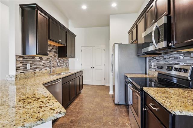 324 Ashton Oaks Ln, Luling, LA 70070 - kitchen with appliances with stainless steel finishes, a sink, dark brown cabinets, decorative backsplash, and recessed lighting