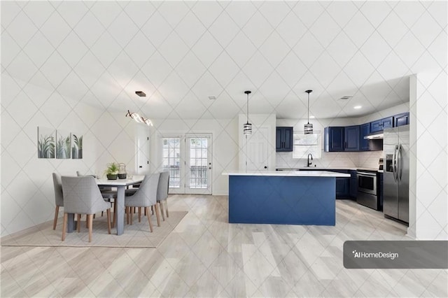 kitchen featuring a sink, light countertops, under cabinet range hood, blue cabinets, and stainless steel appliances