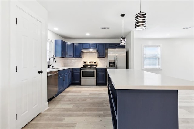 kitchen featuring blue cabinetry, visible vents, a sink, stainless steel appliances, and a wealth of natural light