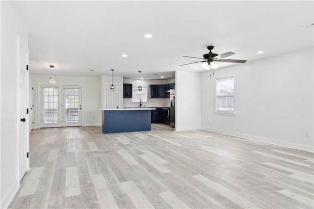 unfurnished living room with baseboards, a ceiling fan, light wood-style floors, and recessed lighting