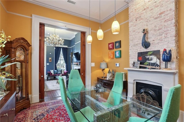 1907 N Rampart St, New Orleans, LA 70116 - living area featuring an inviting chandelier, wood finished floors, a fireplace, crown molding, and visible vents