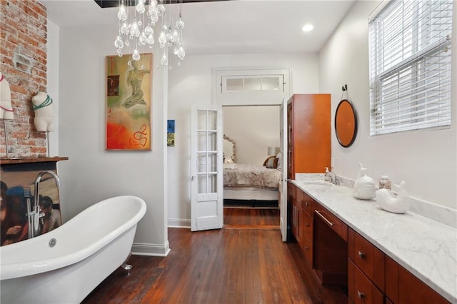 1907 N Rampart St, New Orleans, LA 70116 - ensuite bathroom featuring baseboards, ensuite bath, wood-type flooring, vanity, and a freestanding tub