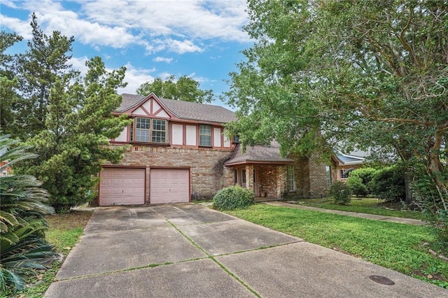 tudor house with brick siding, an attached garage, driveway, and a front yard