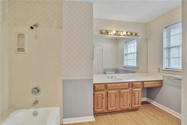 full bath with vanity, a washtub, wallpapered walls, wood finished floors, and a shower