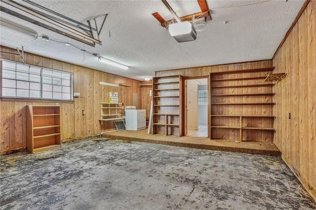 garage with washer / dryer, a garage door opener, and wood walls