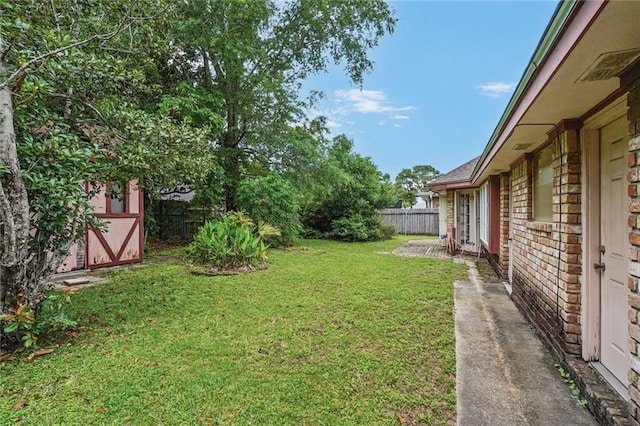 view of yard featuring a fenced backyard, a shed, and an outbuilding