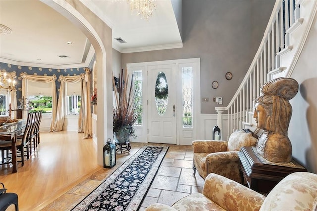 entryway with stone tile floors, an inviting chandelier, and plenty of natural light