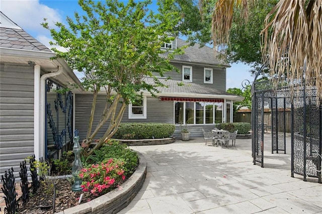 rear view of house featuring fence and a patio area