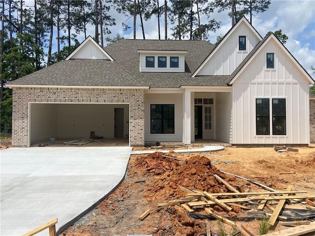 4141 Endor Loop, Mandeville, LA 70448 - view of front of home featuring roof with shingles, brick siding, a garage, board and batten siding, and concrete driveway
