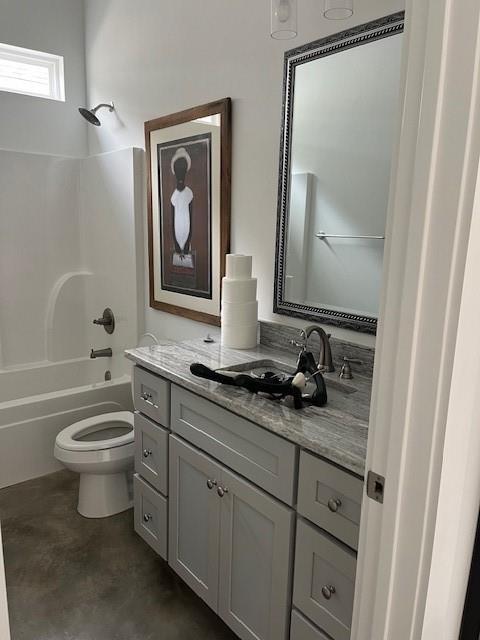 bathroom featuring toilet, washtub / shower combination, finished concrete floors, and vanity