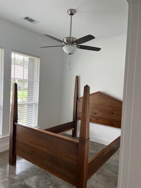 interior space featuring visible vents, a ceiling fan, and concrete flooring