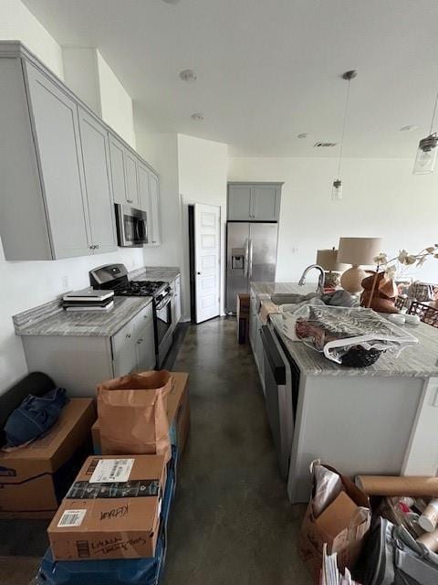kitchen with visible vents, a center island with sink, finished concrete floors, a sink, and appliances with stainless steel finishes