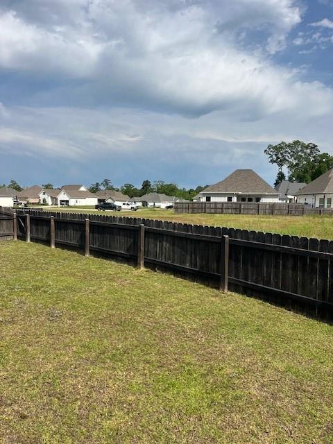 view of yard with a fenced backyard and a residential view