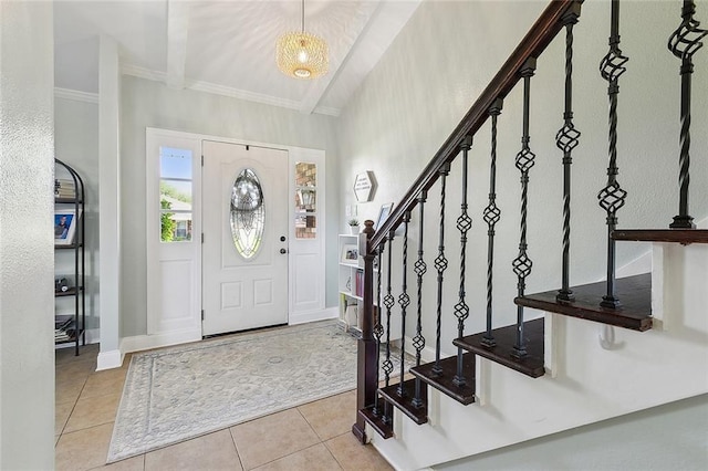 entrance foyer with tile patterned floors, ornamental molding, baseboards, and stairs