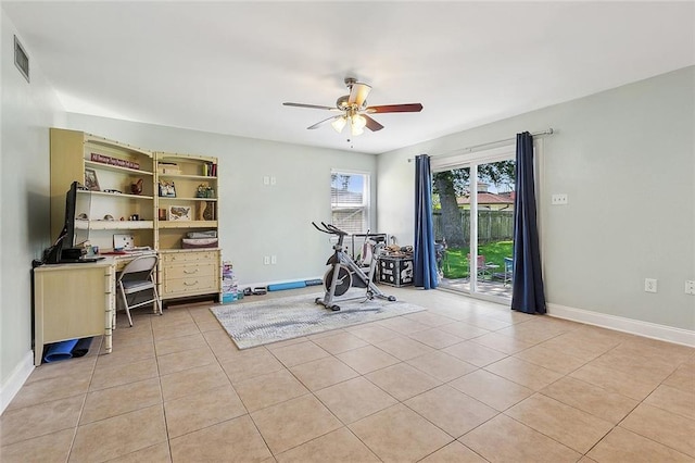 exercise room featuring visible vents, baseboards, ceiling fan, and light tile patterned floors