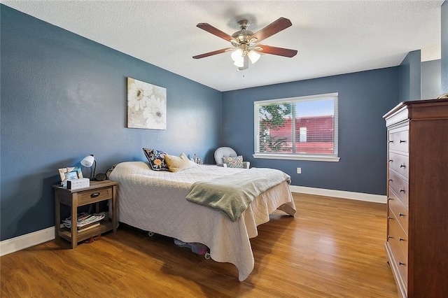 bedroom with baseboards, a ceiling fan, and wood finished floors