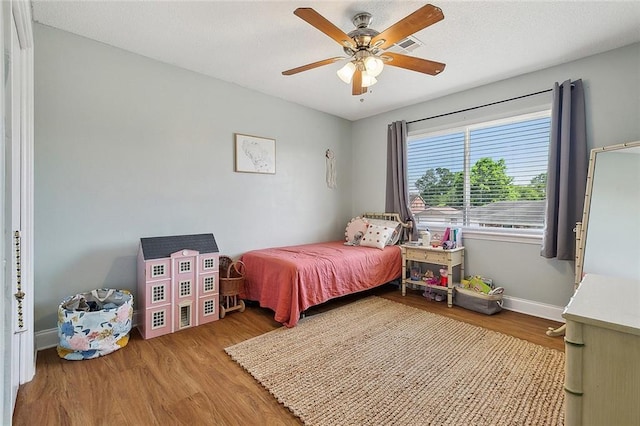 bedroom featuring baseboards, ceiling fan, and wood finished floors