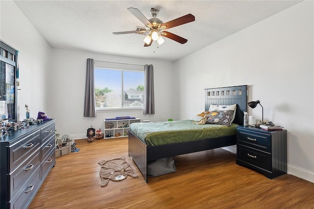 bedroom featuring baseboards, ceiling fan, and light wood-style floors