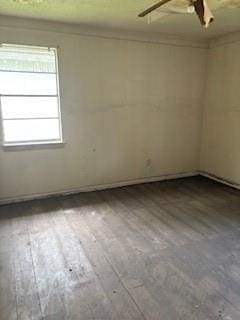 empty room with ceiling fan and hardwood / wood-style flooring