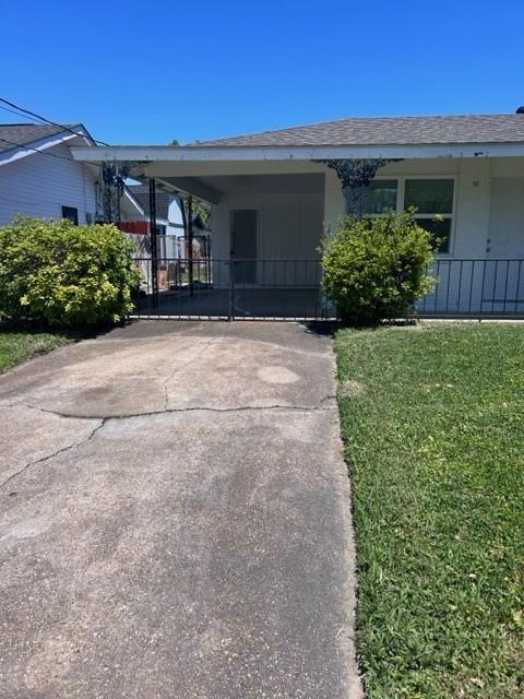 5 Daffodil St, Waggaman, LA 70094 - exterior space with roof with shingles, an attached carport, a yard, and driveway