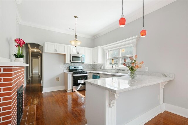 kitchen with a sink, appliances with stainless steel finishes, crown molding, and a peninsula