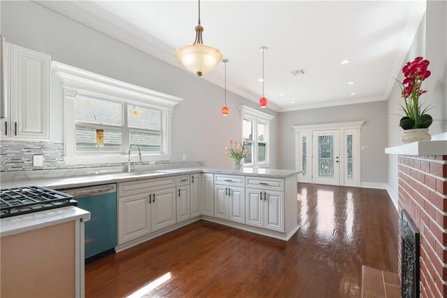 kitchen with visible vents, pendant lighting, a sink, a peninsula, and dark wood-style floors