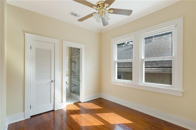 unfurnished bedroom with crown molding, baseboards, dark wood-style floors, and visible vents