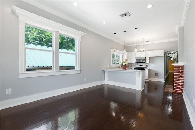 kitchen featuring dark wood-style flooring, appliances with stainless steel finishes, a peninsula, white cabinetry, and visible vents