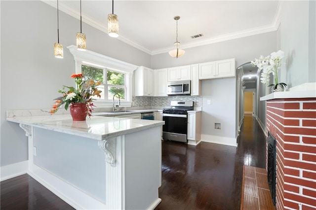 kitchen with dark wood-style flooring, appliances with stainless steel finishes, a sink, a peninsula, and visible vents