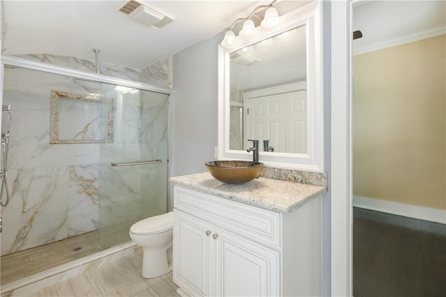 bathroom featuring visible vents, a marble finish shower, toilet, and vanity
