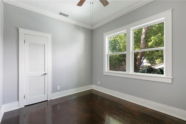 spare room featuring ceiling fan, dark wood-style flooring, visible vents, crown molding, and baseboards