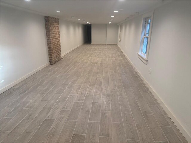 basement featuring baseboards, recessed lighting, and light wood-style flooring