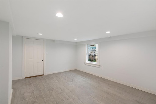spare room featuring baseboards, recessed lighting, and light wood-style flooring