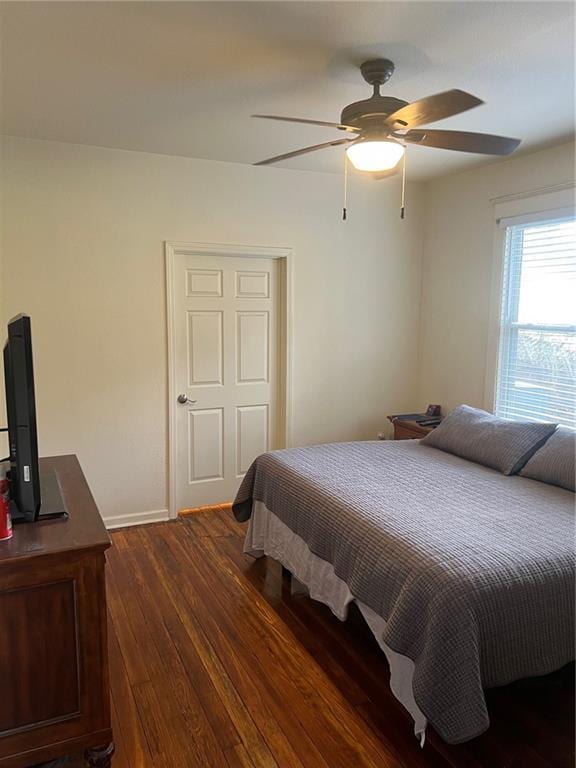 bedroom with a ceiling fan, baseboards, and dark wood finished floors