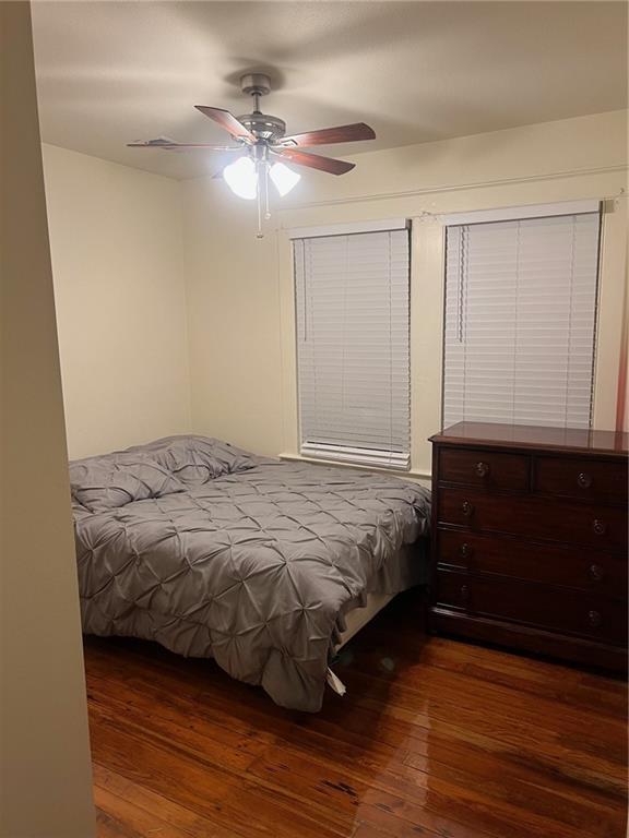 bedroom with a ceiling fan and dark wood-style flooring