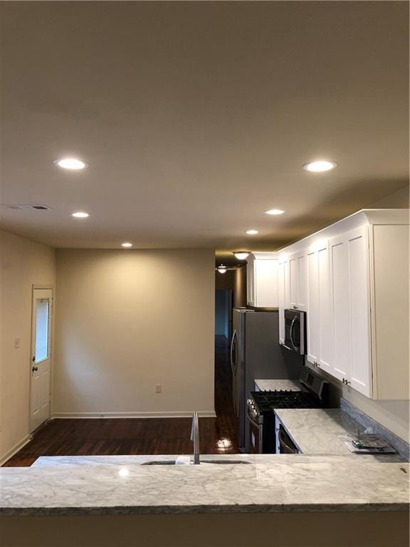 kitchen featuring white cabinets, a sink, stainless steel appliances, recessed lighting, and dark wood-style floors