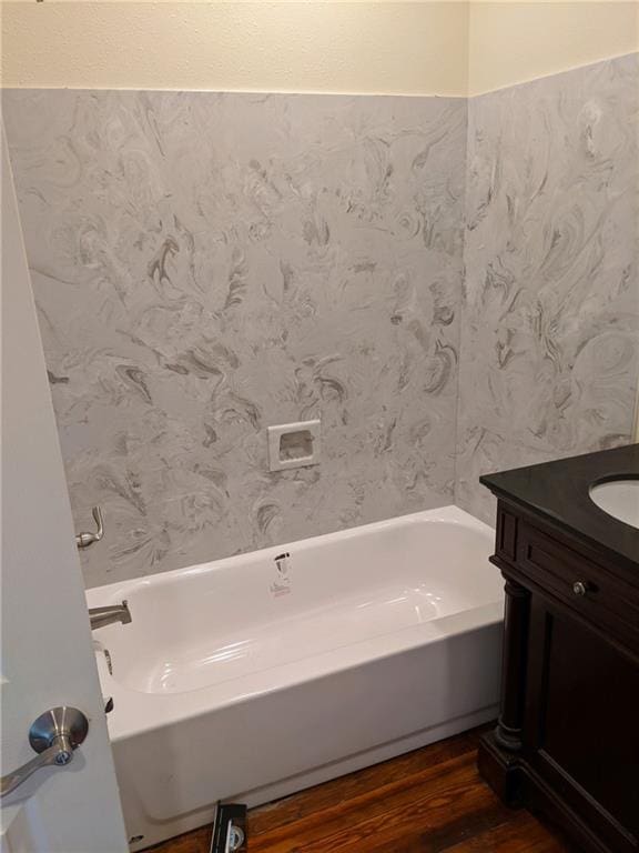 bathroom featuring a bathtub, wood finished floors, and vanity