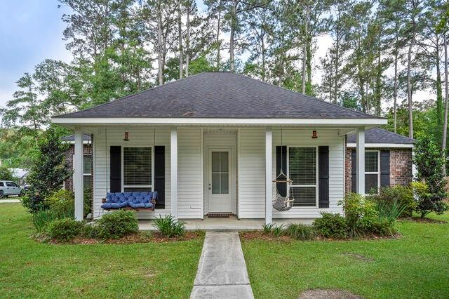 bungalow featuring a shingled roof, a porch, and a front yard