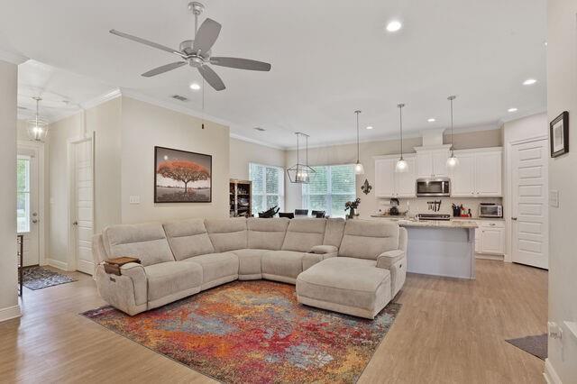 166 Egret St, Covington, LA 70433 - living room featuring light wood-style floors, recessed lighting, ceiling fan, baseboards, and crown molding