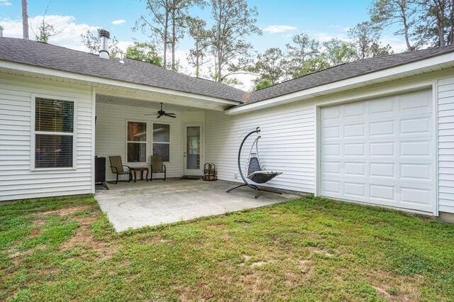 back of property with a yard, a ceiling fan, and a patio area