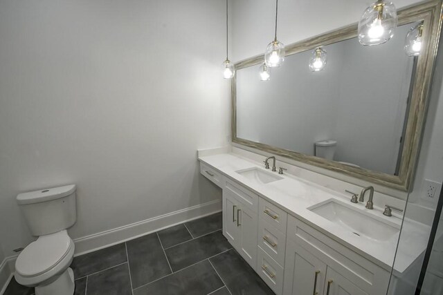 bathroom with toilet, baseboards, a sink, and tile patterned floors