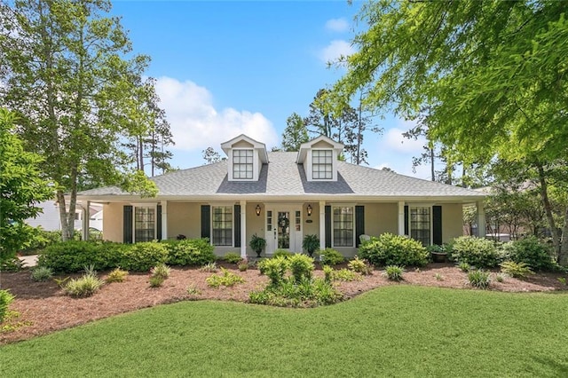 view of front facade with a shingled roof, stucco siding, and a front lawn