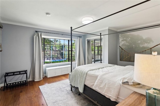 bedroom with ornamental molding and wood finished floors