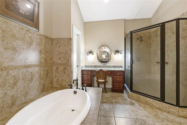 bathroom featuring tile patterned floors, a shower stall, a garden tub, and vanity