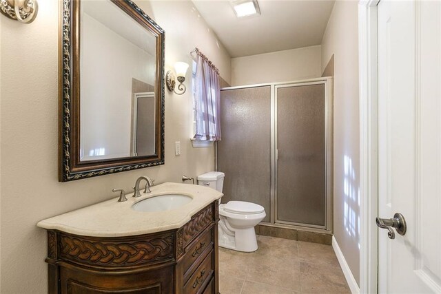 bathroom with vanity, toilet, tile patterned flooring, and a stall shower