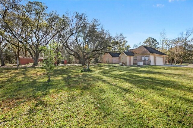 view of yard featuring an attached garage and driveway
